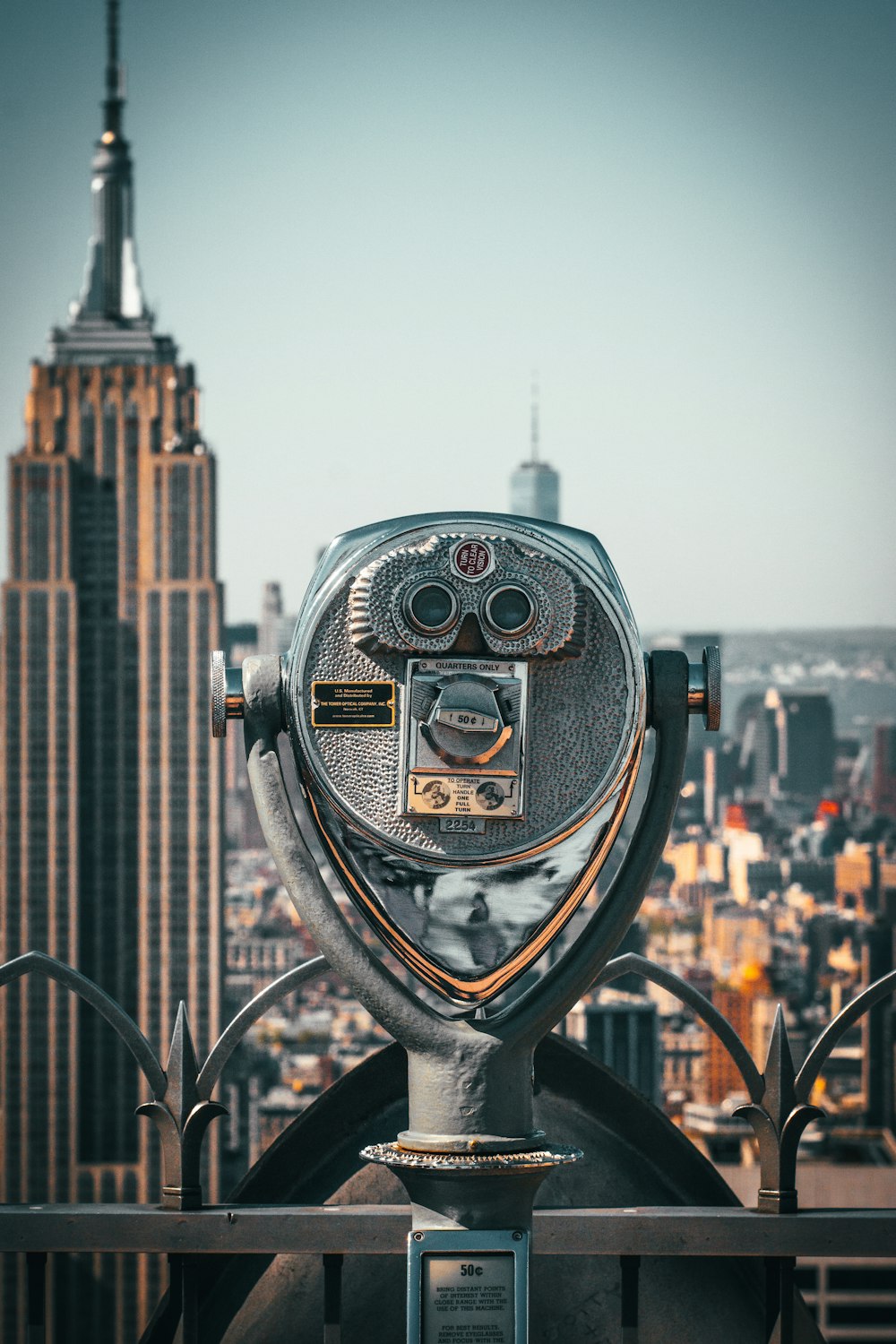 a metal object with a face on it with a city in the background