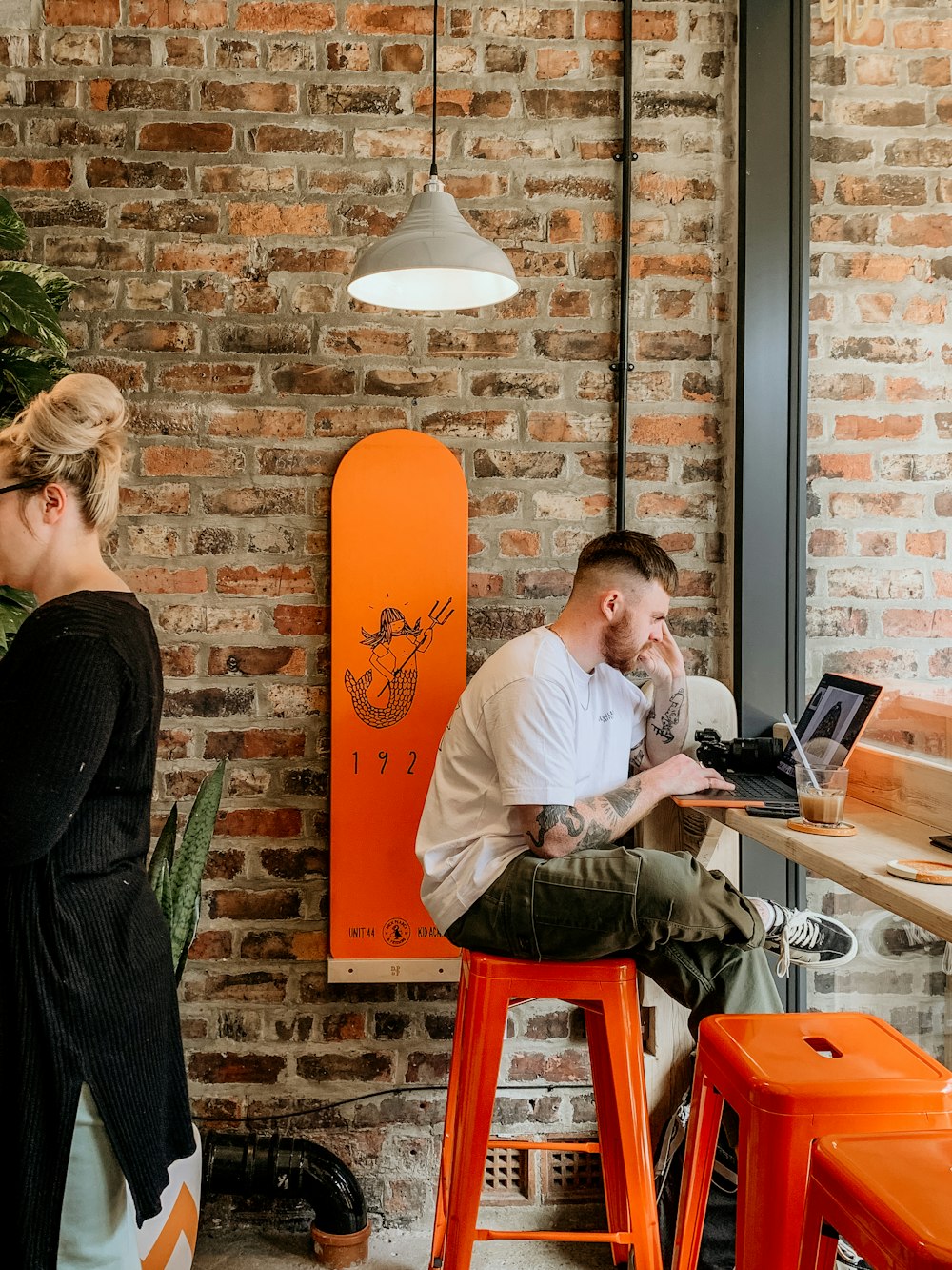 a man and woman sitting at a table with laptops