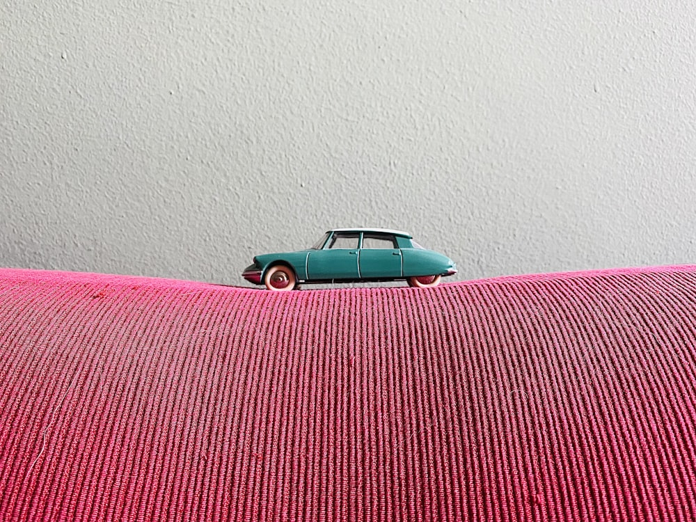 a toy car on a red surface