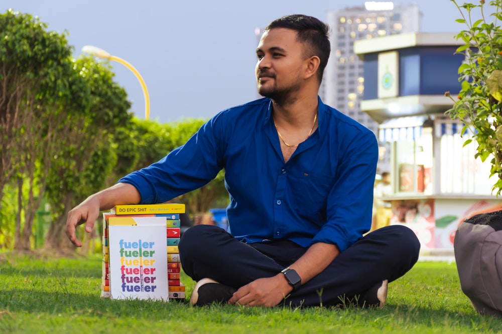 a man sitting on the grass with a box of cereal