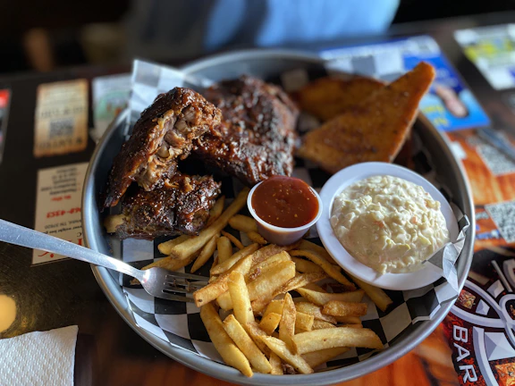 A vibrant platter of southern sides including fries, coleslaw, and mac and cheese.