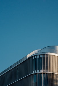 A sleek modern building under clear blue sky showcasing strong structural design.