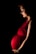 A pregnant woman stands gracefully, illuminated by soft lighting against a dark background. She wears a vibrant red dress that accentuates her belly, and a floral headpiece rests on her head. Her gaze is gentle and focused downward.