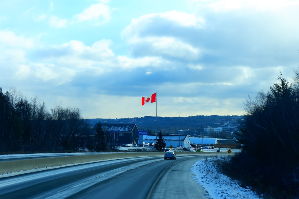 a car driving on a road with a flag on it