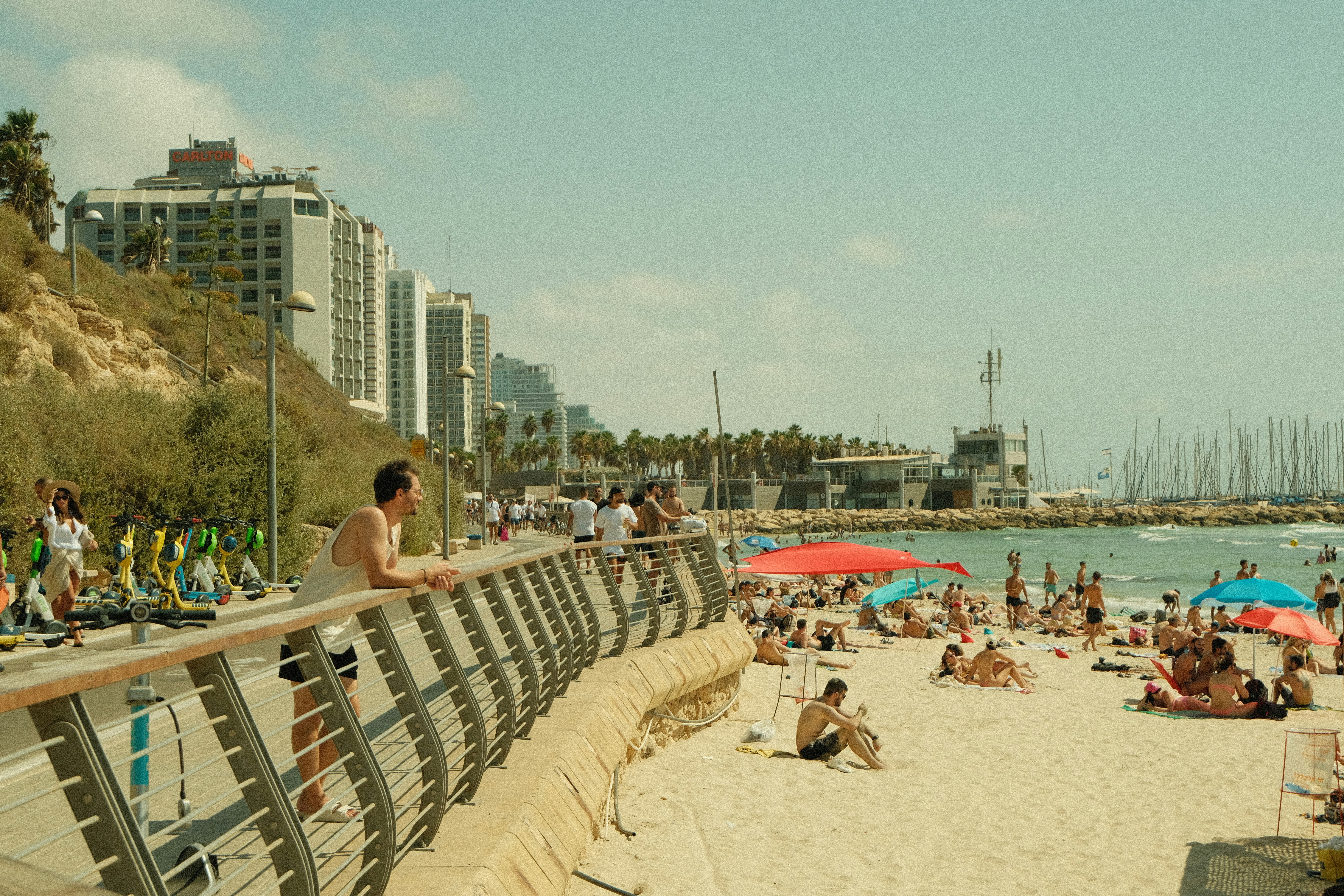a beach with people and umbrellas