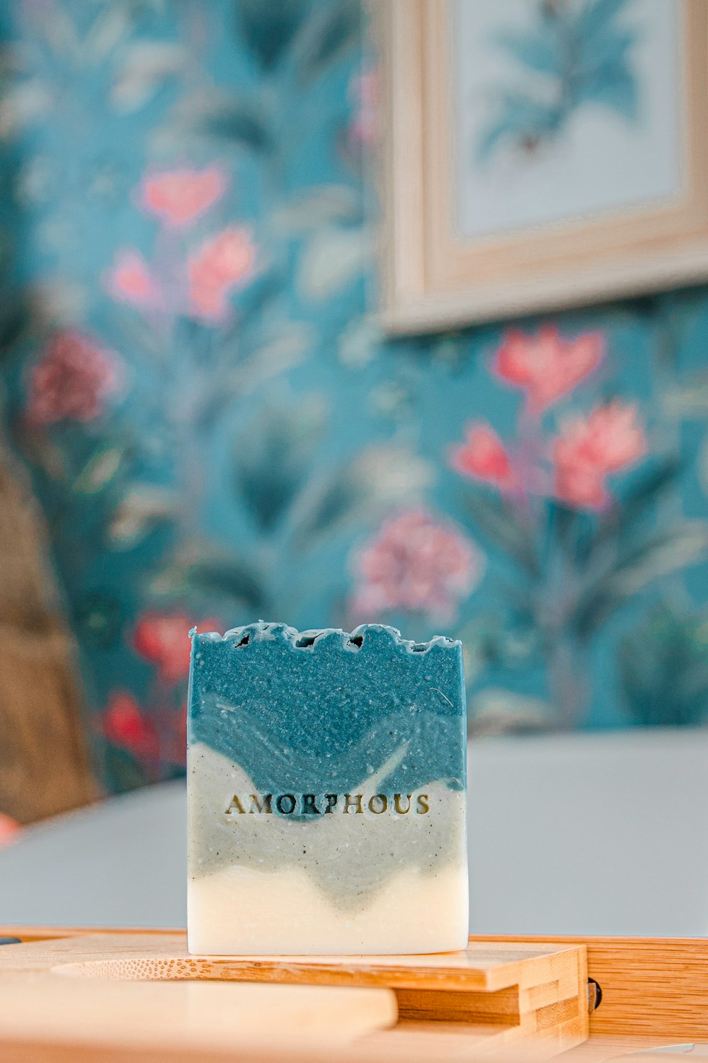 a white cake with a blue frosting on a wooden surface