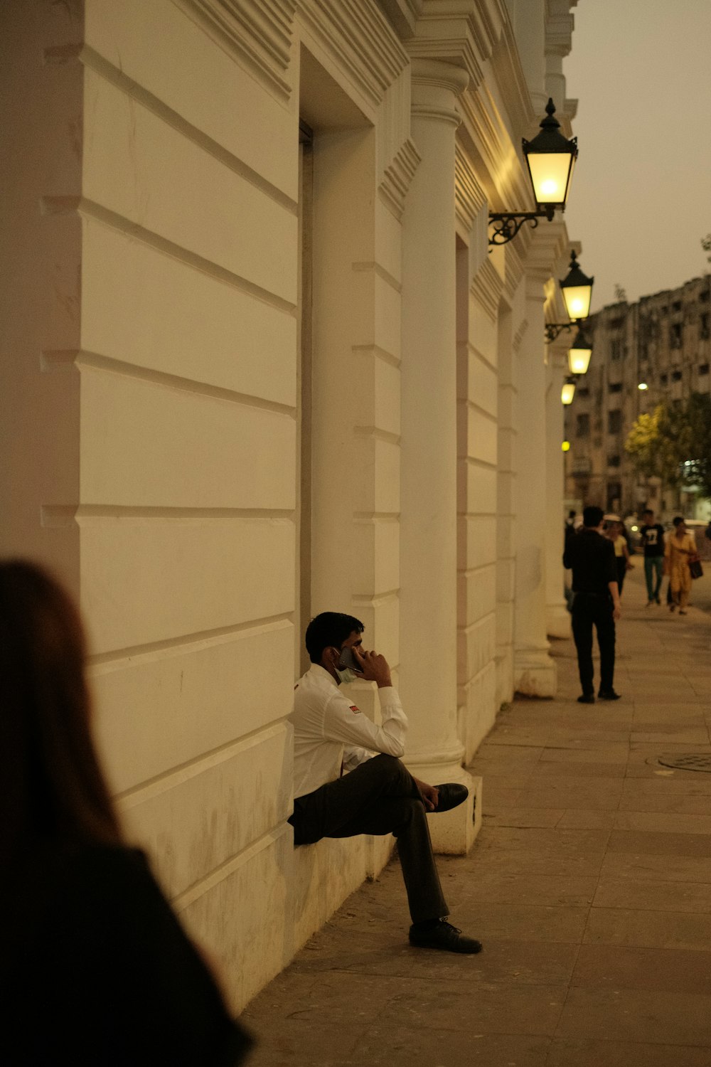 a person sitting on a sidewalk