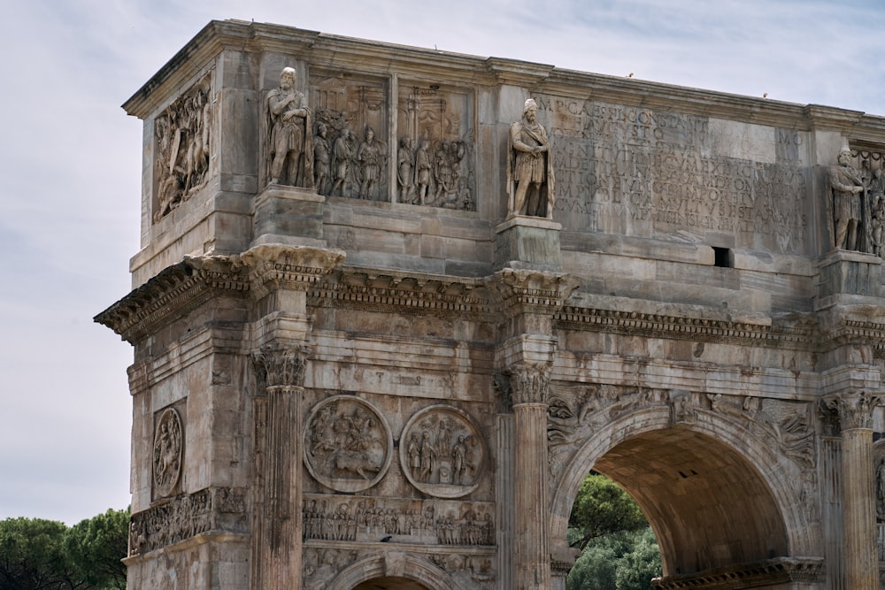 a stone building with statues on the top