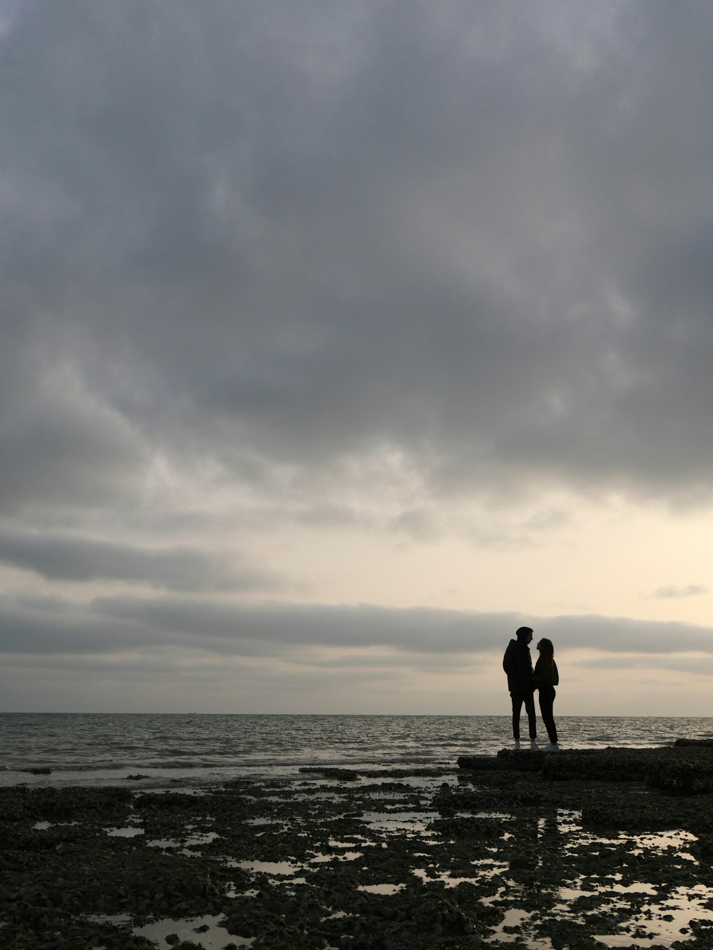 two people standing on a beach