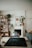 A cozy living room featuring various natural and artificial plants on a stylish shelf.