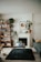 A cozy living room featuring various natural and artificial plants on a stylish shelf.