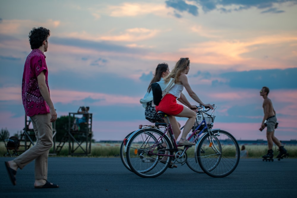 a group of people walking and riding a bicycle