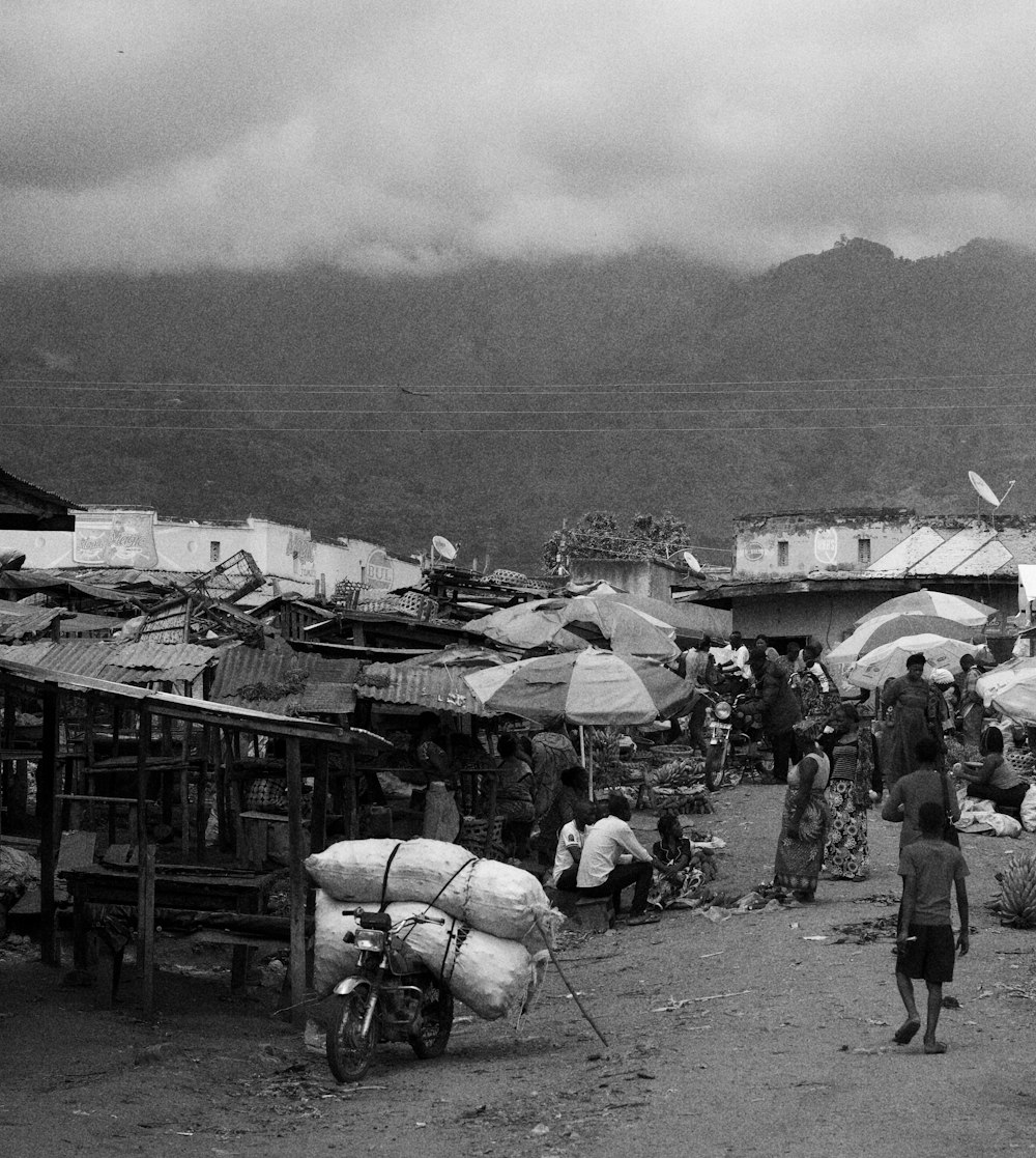 a group of people stand outside a small village