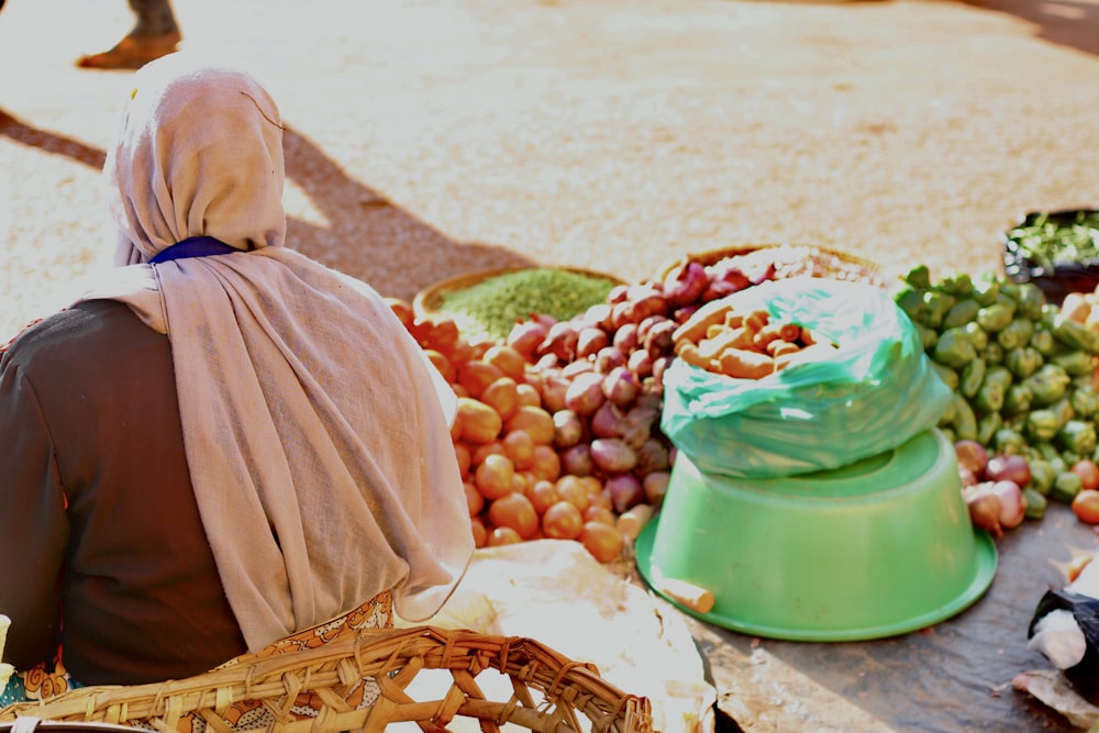 a person sitting next to a basket of fruit