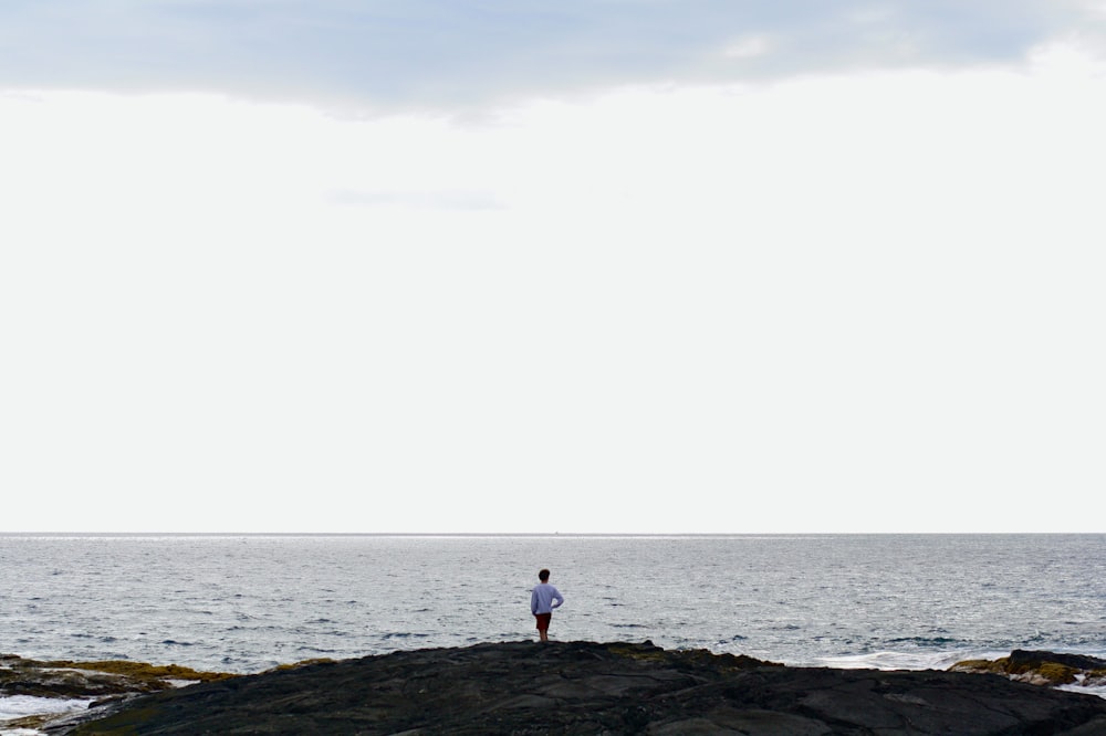 a person standing on a rocky shore