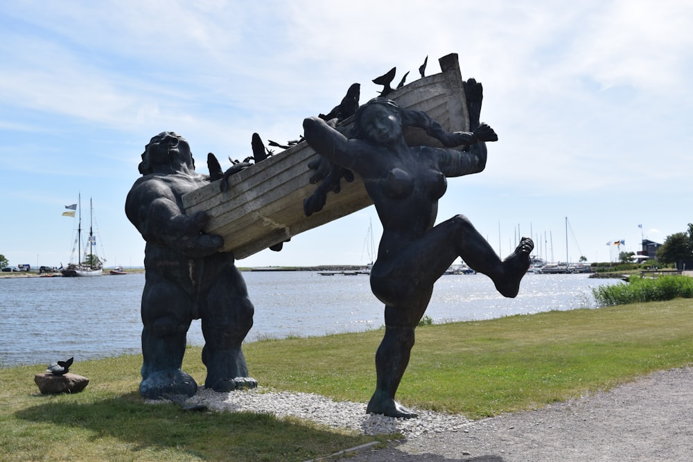 a statue of a group of people holding hands by a body of water