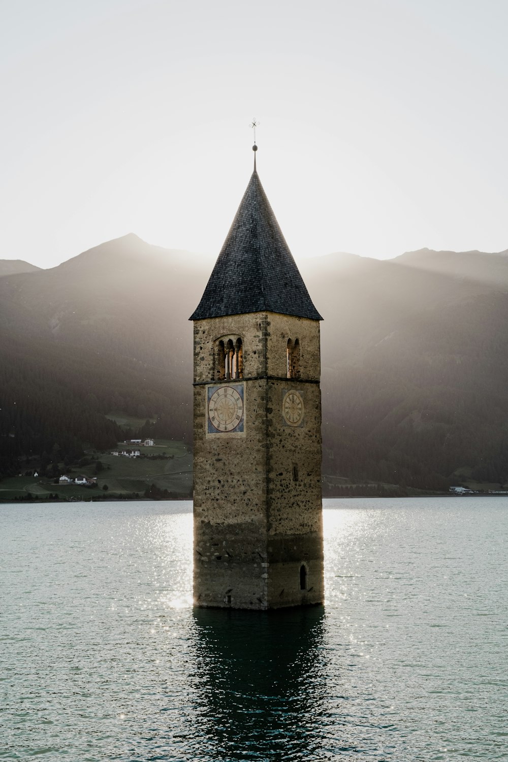 a clock tower in the middle of a body of water