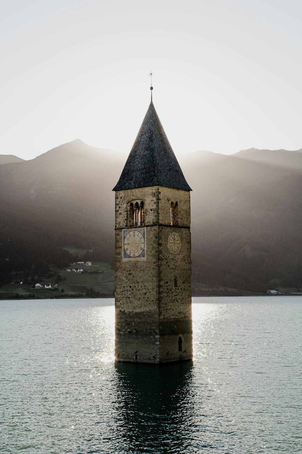 una torre del reloj en medio de un cuerpo de agua