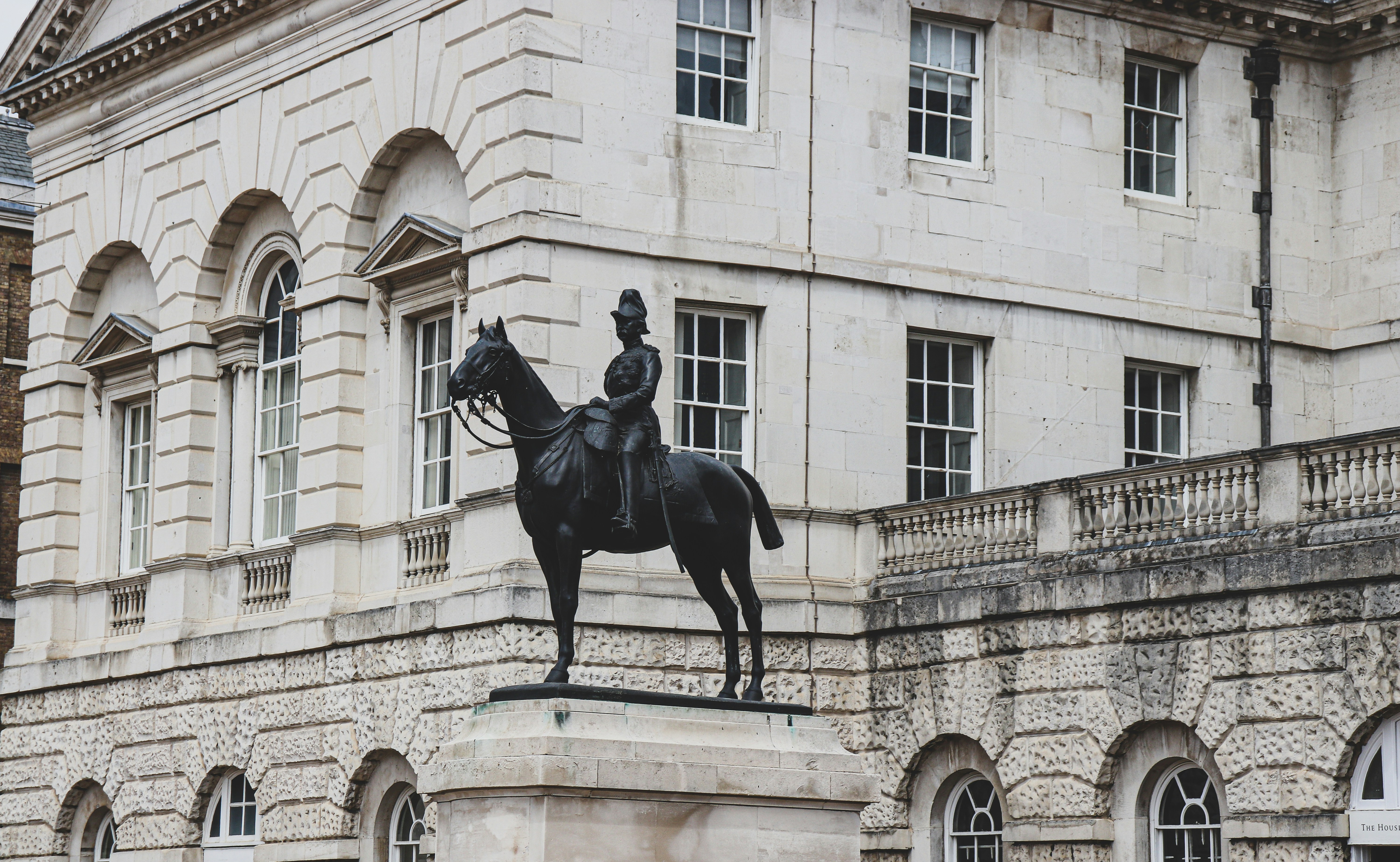 a statue of a person riding a horse in front of a building