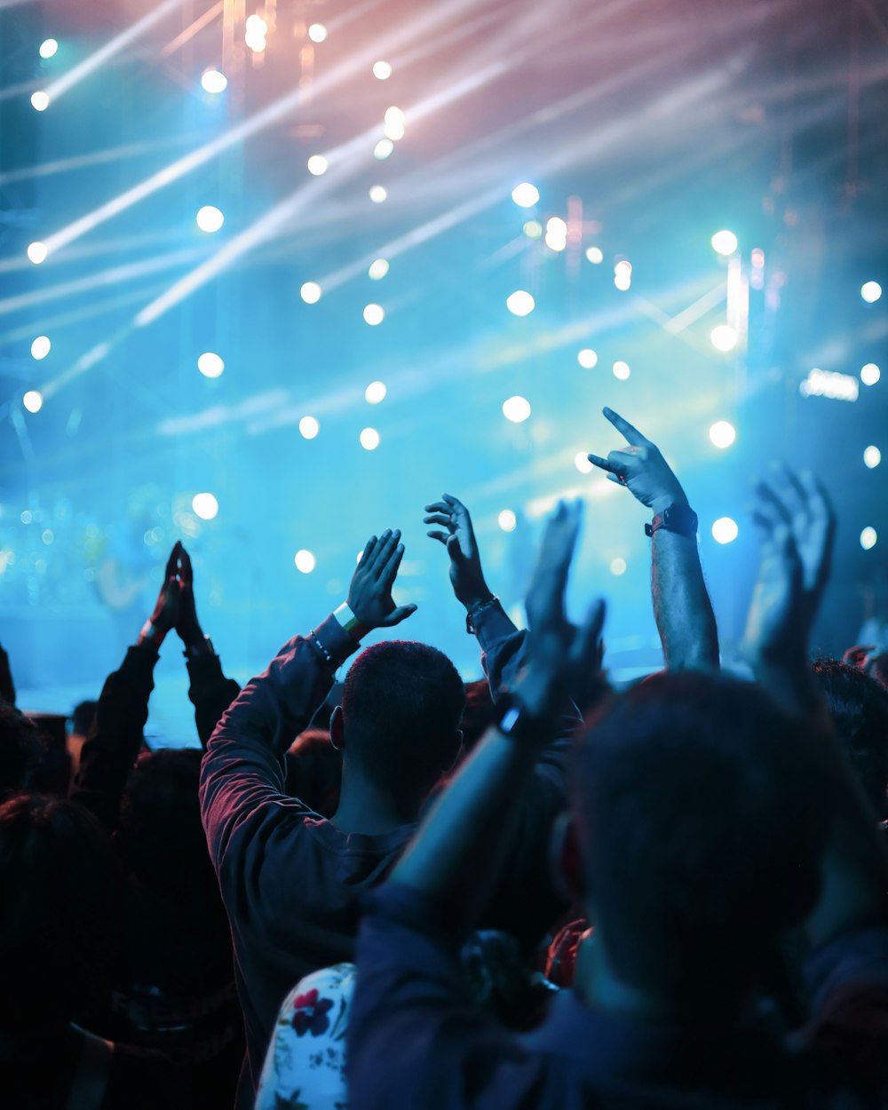 a crowd of people with their hands up in the air