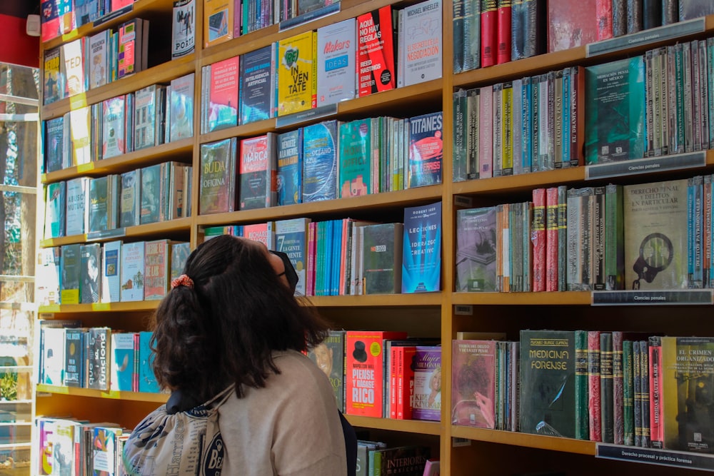 a person looking at a book shelf