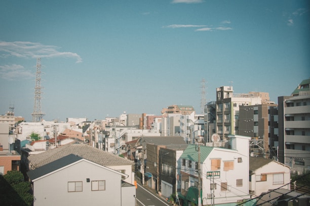A vibrant urban landscape featuring a mix of residential and commercial buildings under a clear blue sky.