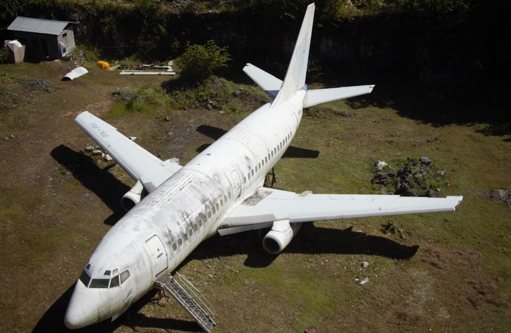 a white airplane on a grassy hill