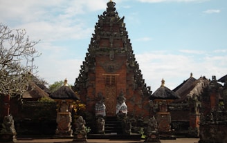 a temple with statues with Scott Monument in the background