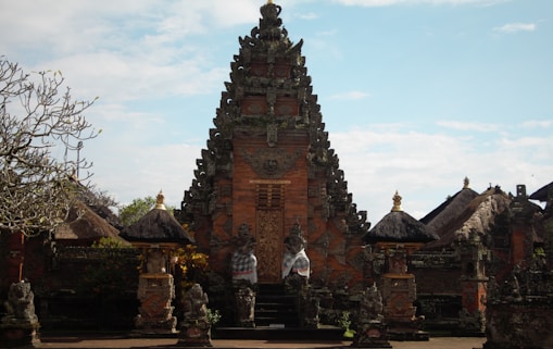 a temple with statues with Scott Monument in the background