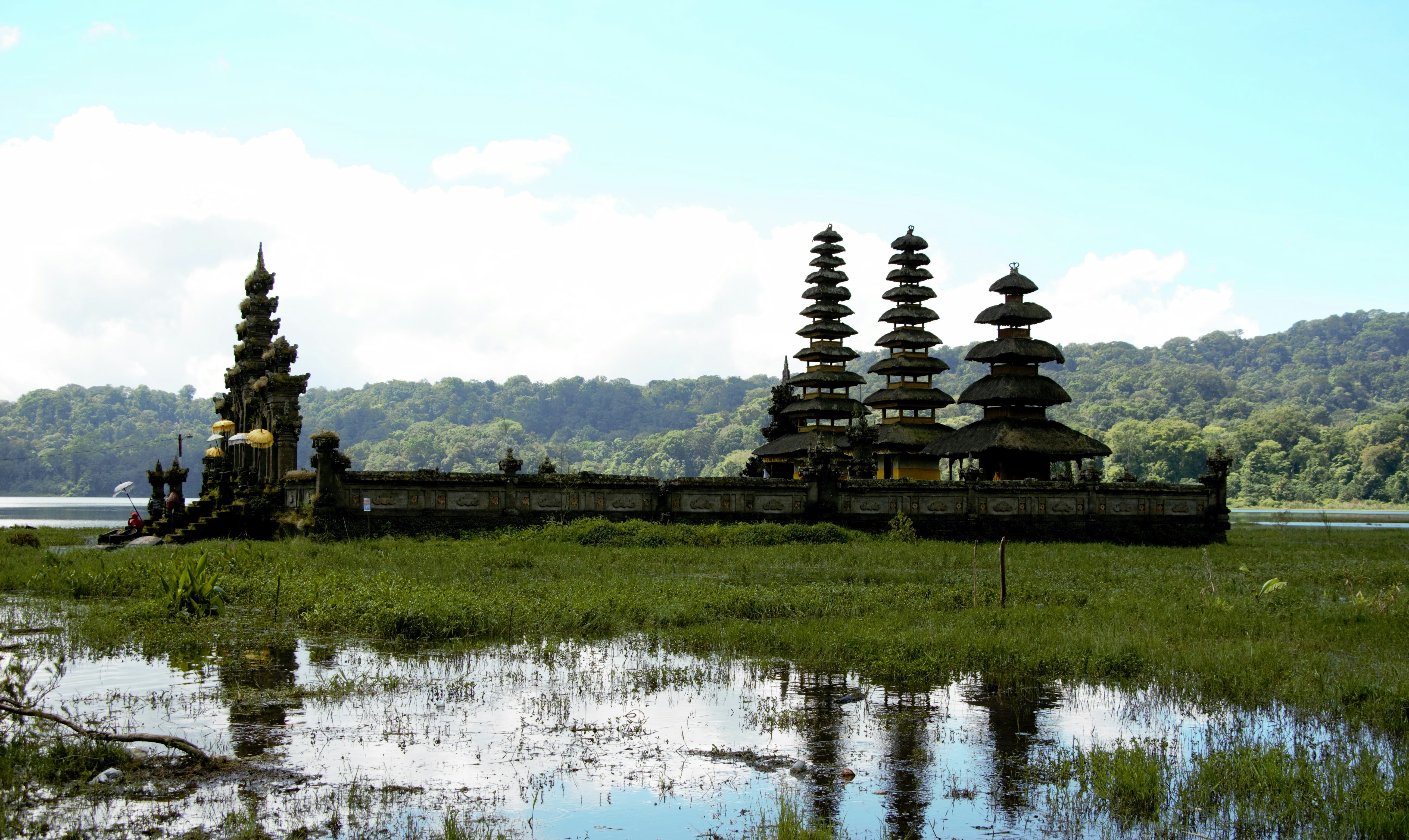 a body of water with a building in the background, Our guide suggested we visit a unique temple that does not see many tourists since we were in Buleleng. When we reached here, there was a local family who had just finished some prayers at this temple.</p><p>We were told the temple was closed and the water was about knee-length. This is a beautiful temple, any time of the day. It was peaceful, almost tourist-free, and simply stunning.