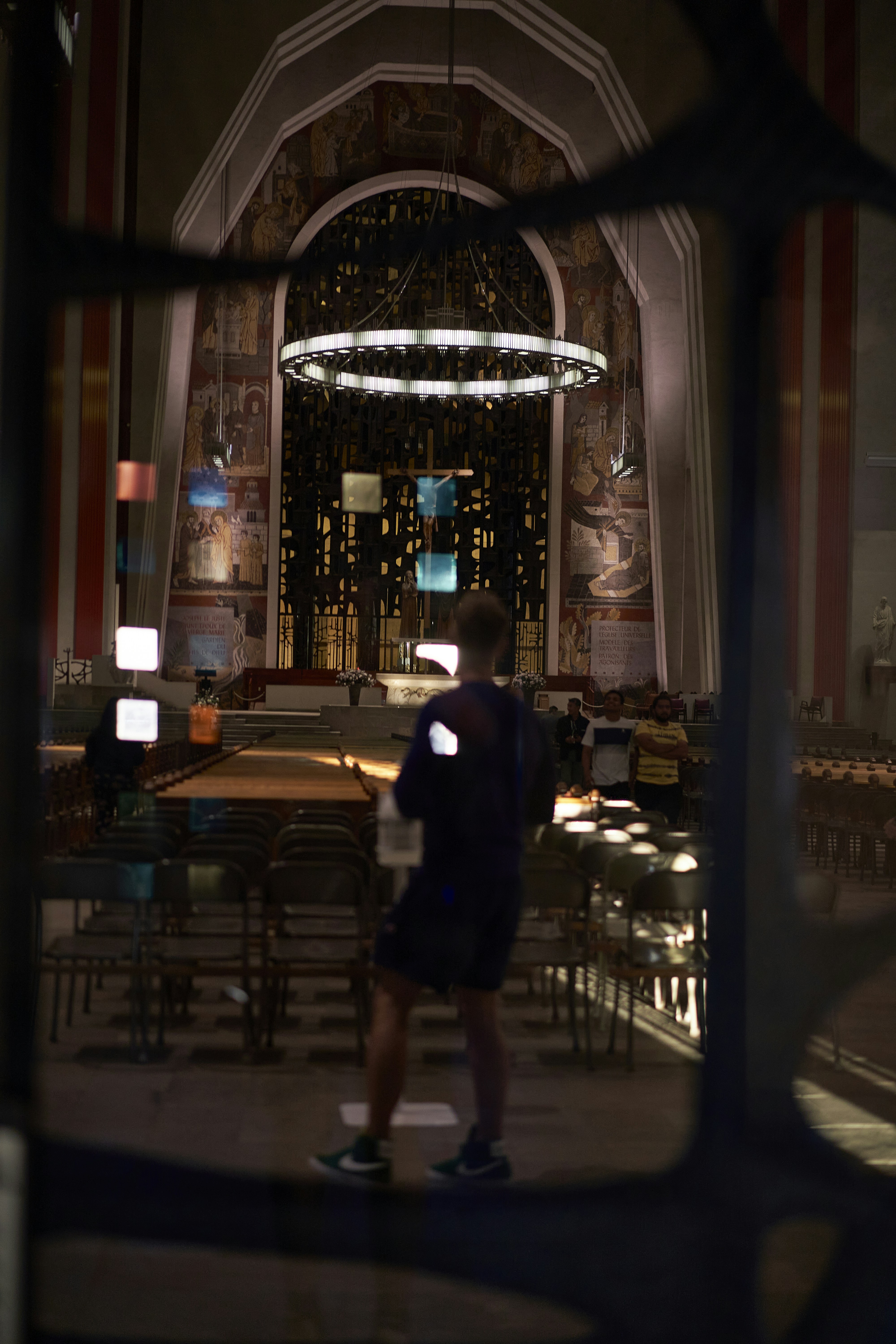 a man standing in a room with a large chandelier