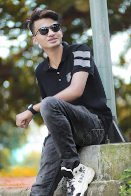 Model wearing a sleek polo shirt paired with casual pants in a sunlit urban setting.