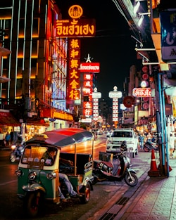 a street with neon signs and scooters