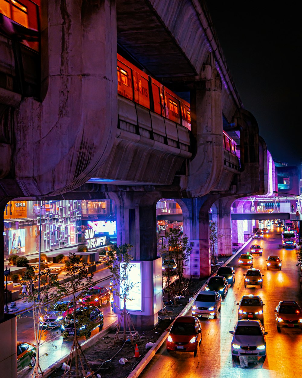 a street with cars and buildings with lights