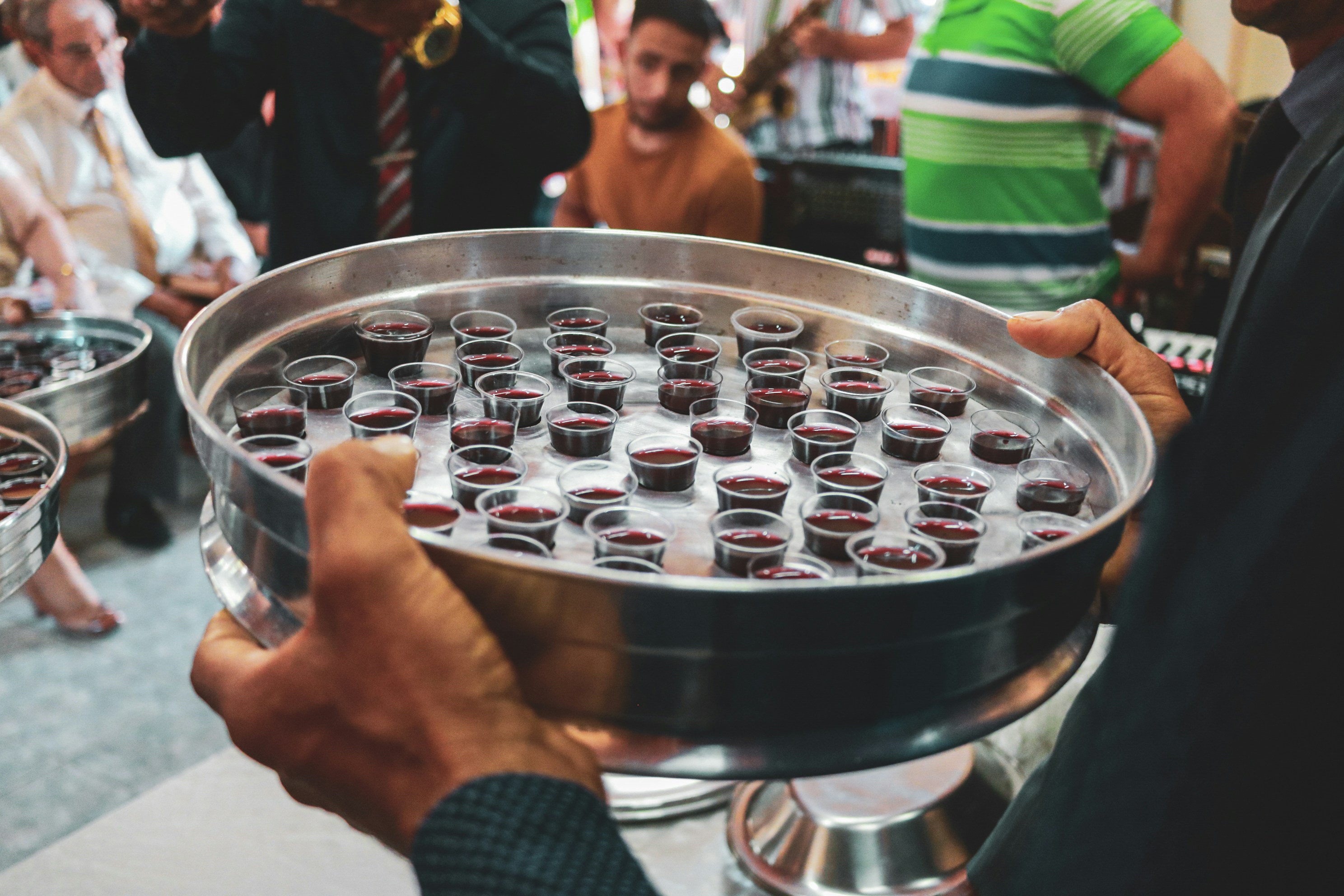 a person holding a large silver container filled with small bottles