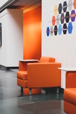 a room with orange chairs and a table