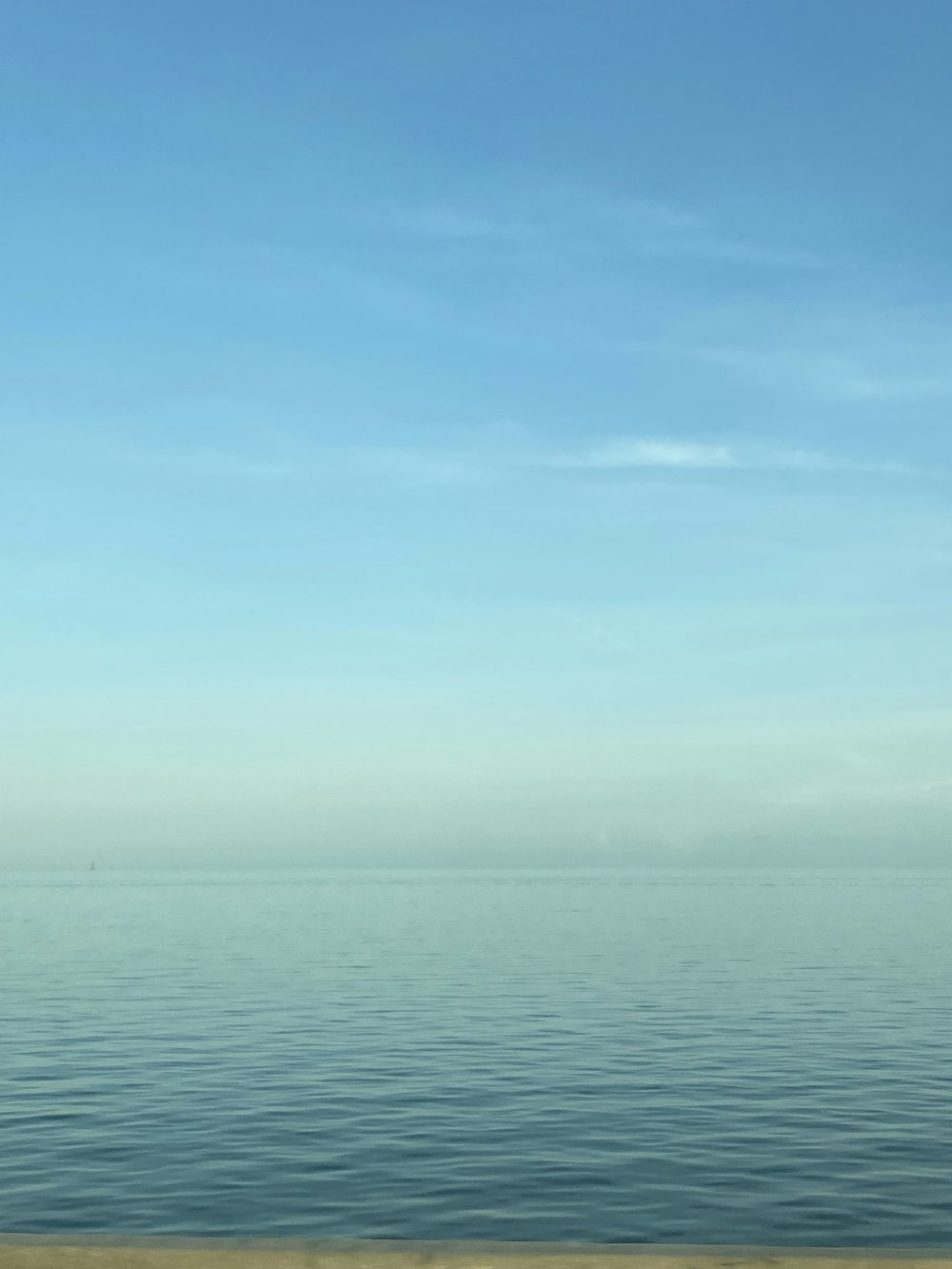 a body of water with a blue sky above it