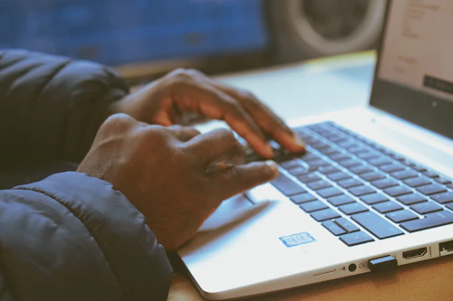 Close-up of hands typing on a laptop during a lesson