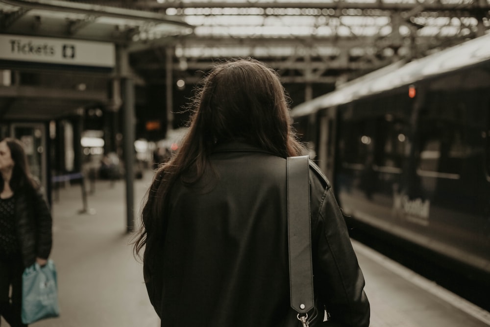 a woman walking down a train platform