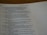 A close-up of an open book displaying a passage from the Bible. The text is printed in black ink on white paper, with some lines highlighted in bold. A dotted line is visible on the right side of the page.