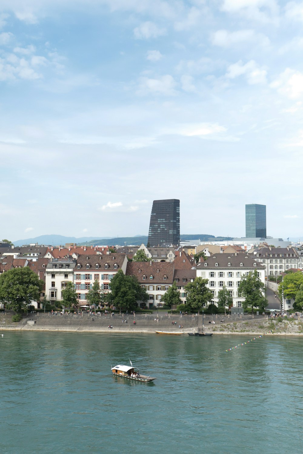 a boat in the water by a city