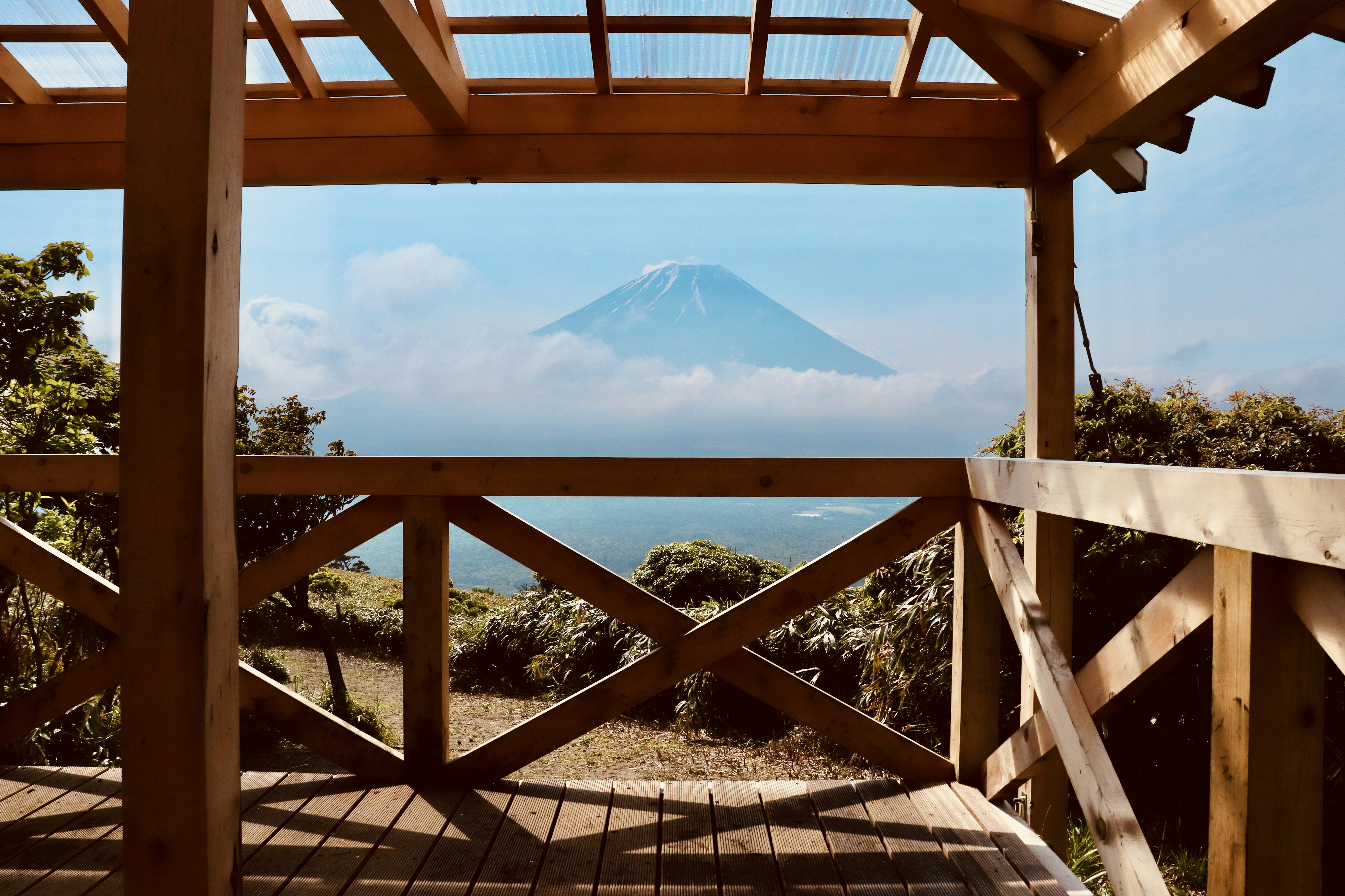 a wooden deck with a view of a mountain and trees