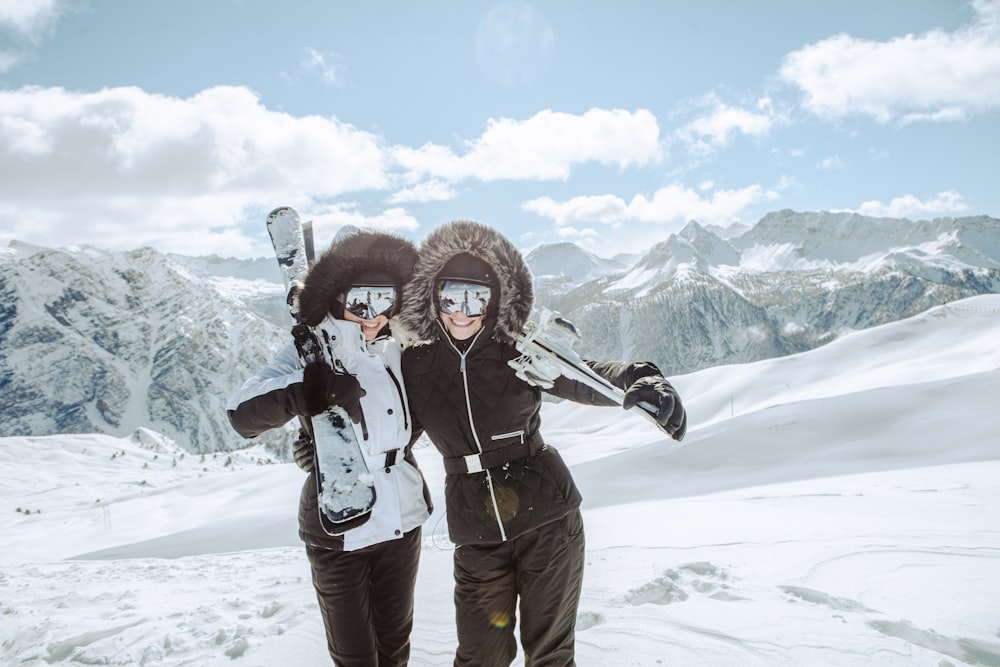 a couple of people pose for a picture with snowboards