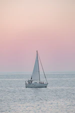 A serene cruise ship gliding through calm blue waters at sunset.