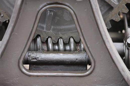 Close-up of durable rotavator gears and axle parts arranged neatly on a workshop table.