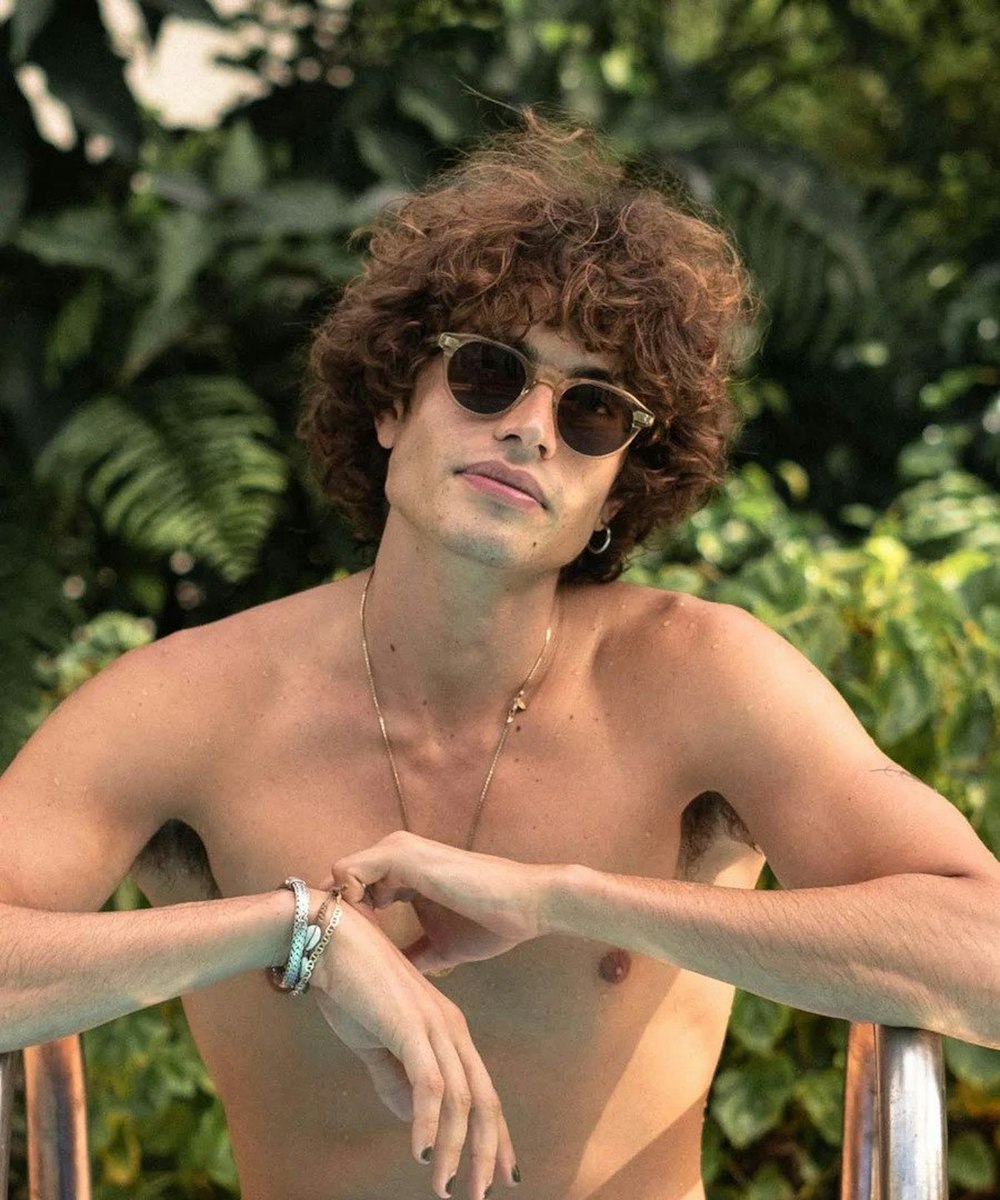 a person with curly hair wearing sunglasses
