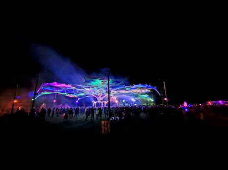 A vibrant film festival scene with people enjoying outdoor screenings under string lights.