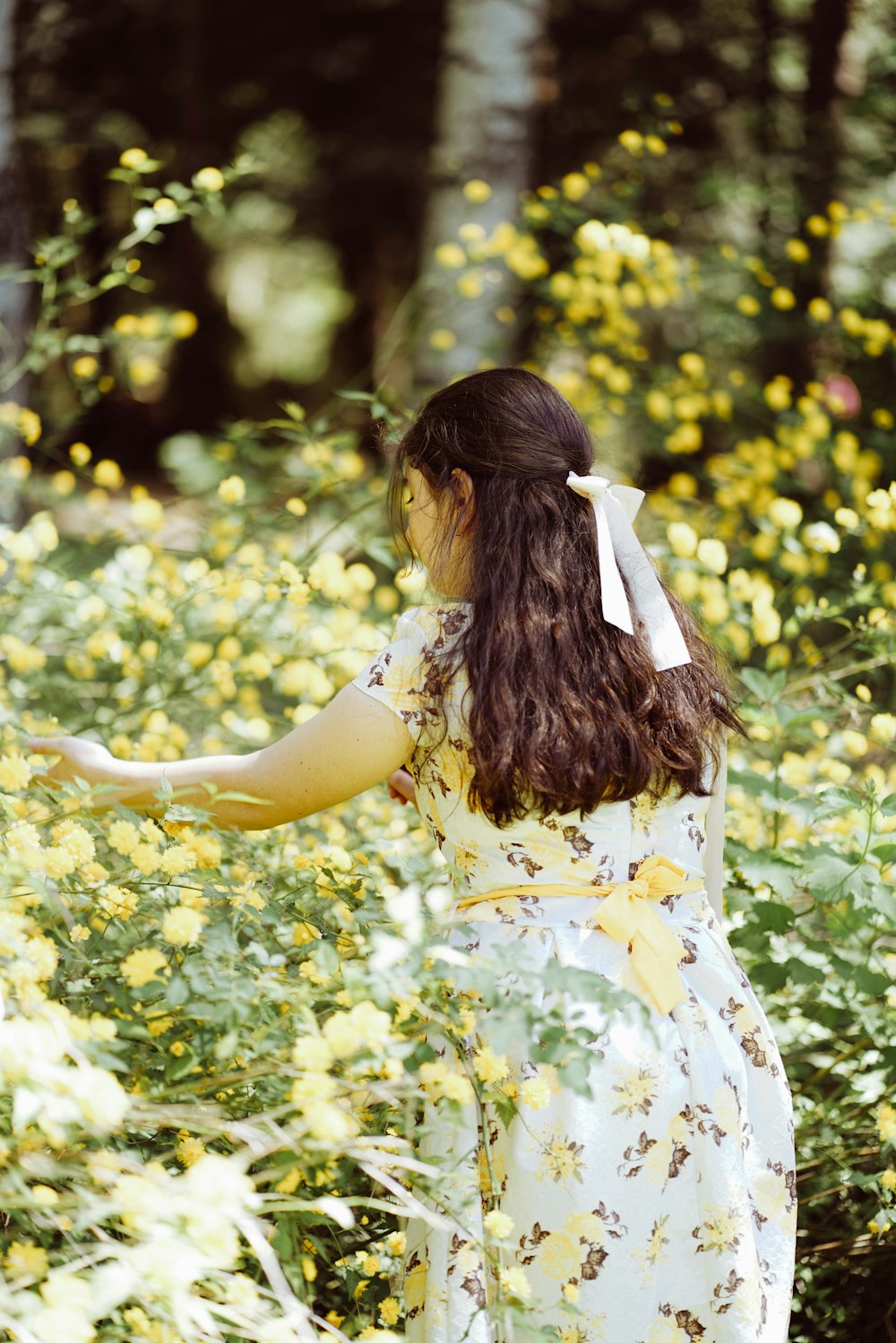 une personne en robe blanche dans un champ de fleurs