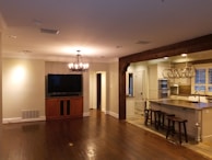 Open floor plan inside a barndominium featuring a kitchen island and rustic decor.
