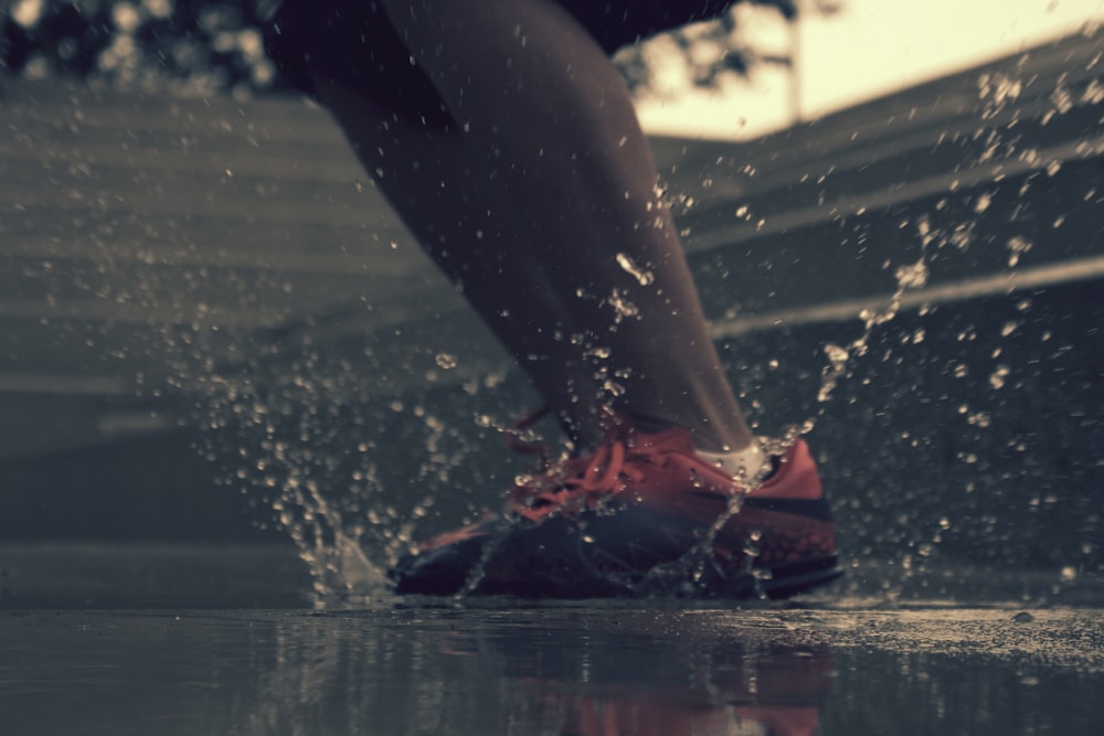a person's feet in a shoe on a wet surface